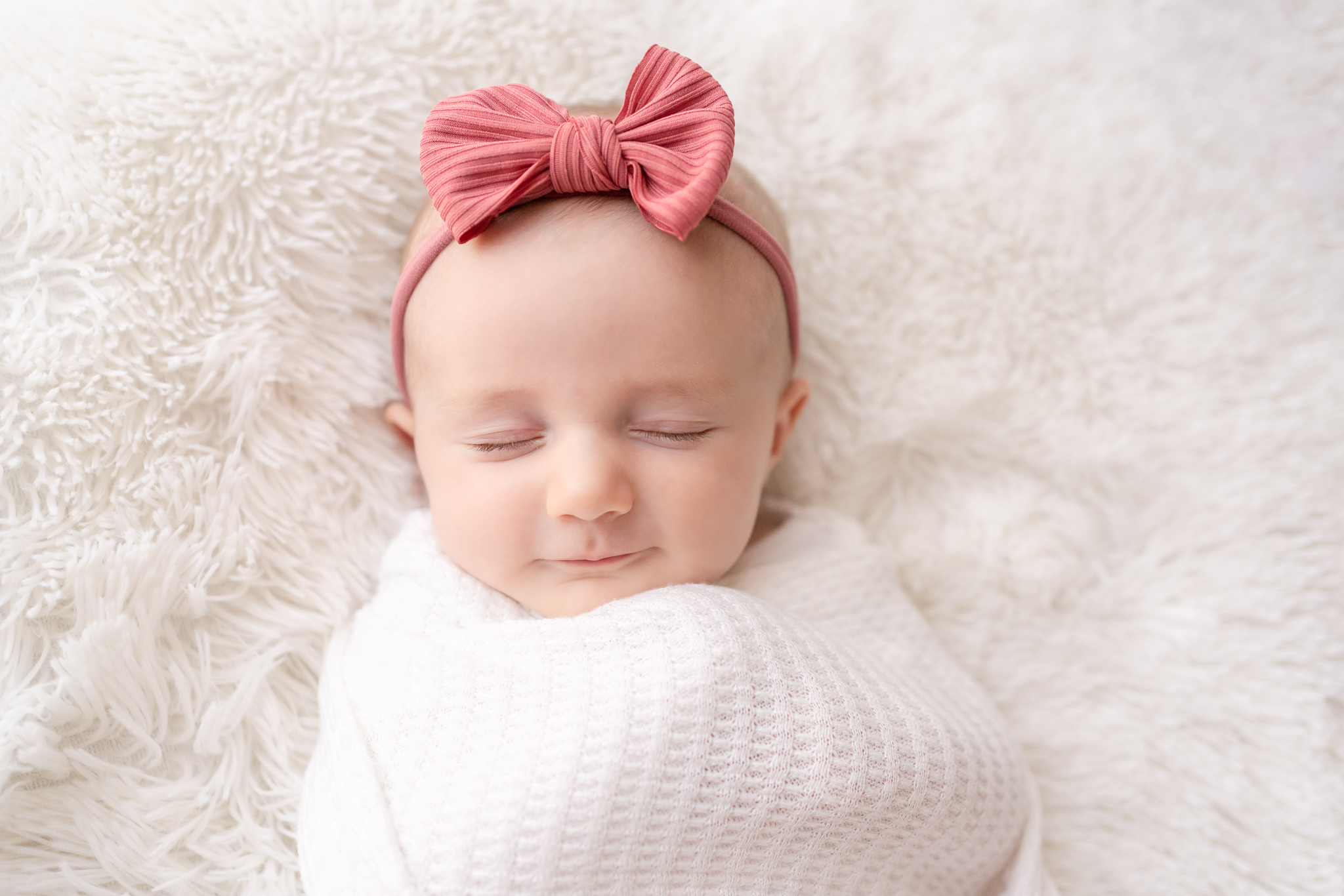 baby grilled with pink bow swaddled in white
