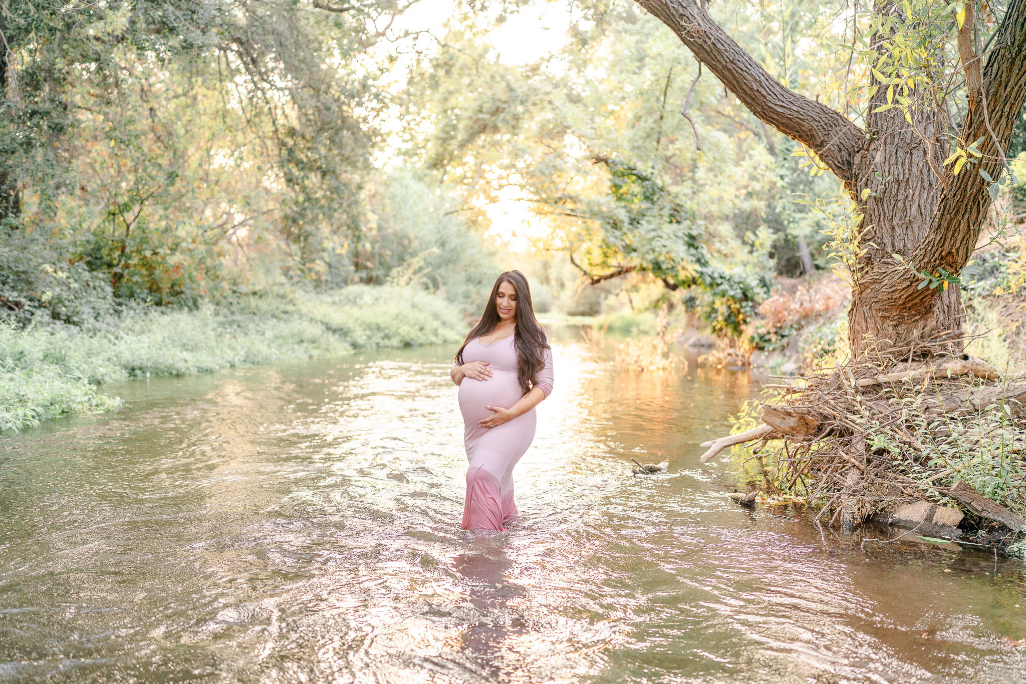 woman in pink dress standing in a creek